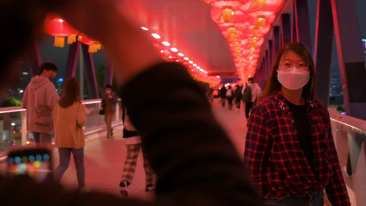 A girl poses for a photo at a pedestrian bridge decorated with Chinese red lanterns hanging from the ceiling to celebrate the Chinese Lunar New Year festival in Hong Kong