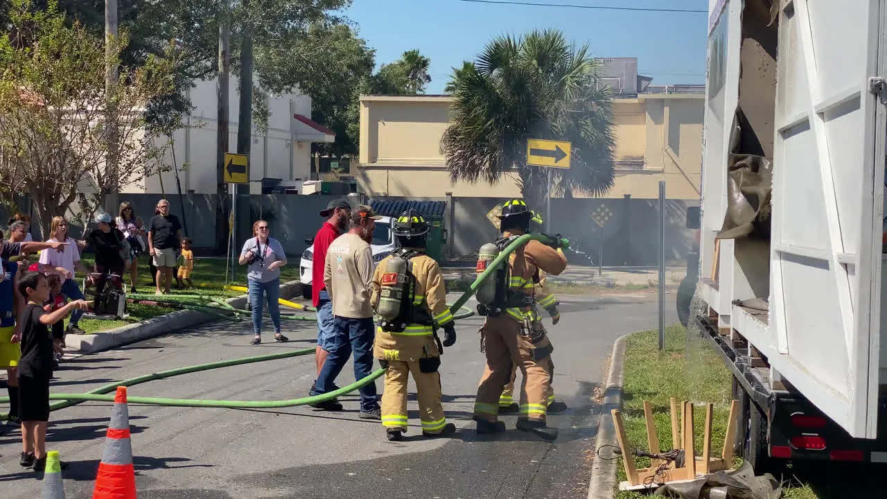 Fire Fighters Spraying Down Burning Couch and Rug For an Educational Demonstration on Fire and Safety at the Anual Fire Station Open House in Tampa Florida