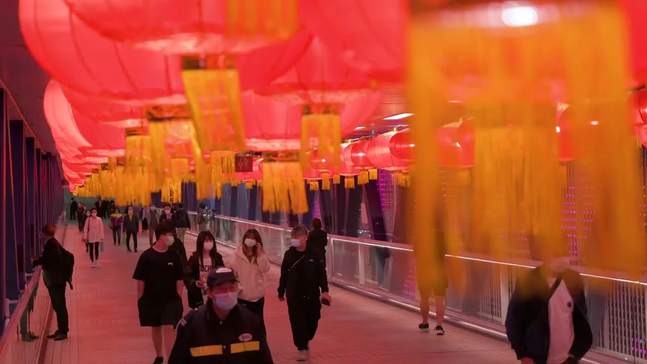 Commuters are seen walking through a pedestrian bridge decorated with Chinese red lanterns hanging from the ceiling to celebrate the Chinese Lunar New Year festival in Hong Kong