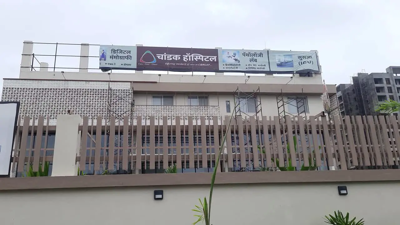 Front view of a modern Chandak Cancer hospital building and surrounding area on a piece of ground