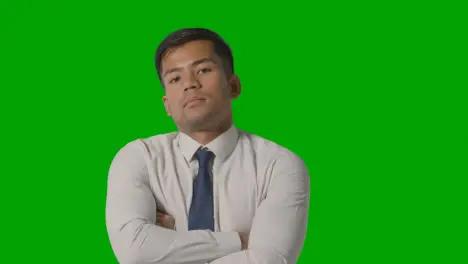 Portrait Of Serious Businessman In Shirt And Tie Against Green Screen Looking At Camera 