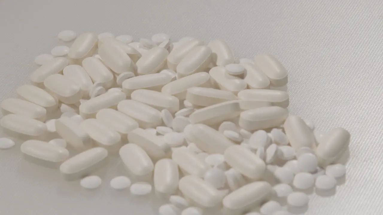 Close Dolly of various pills on a white surface