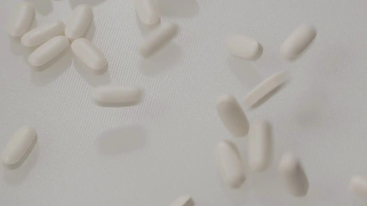 Pills falling on a white background