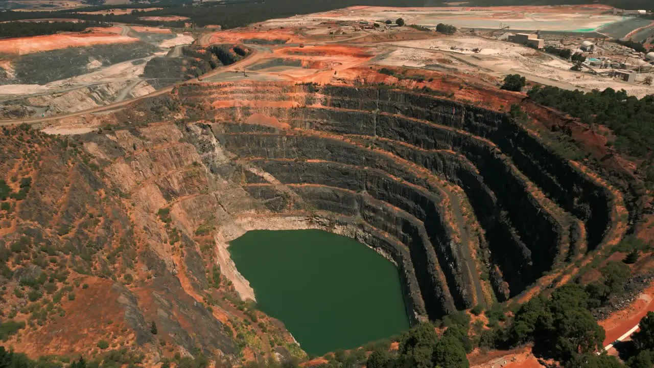 drone shot of an abandoned mine pit in the foreground and a mining site in the background in Western Australia