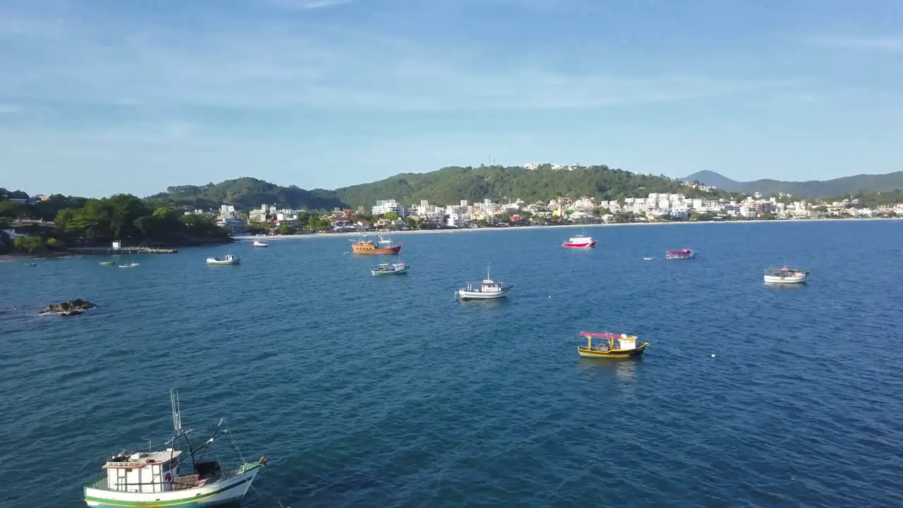 Aerial shot flying over fishing boats working on the sea near Bombinhas beach Brazil