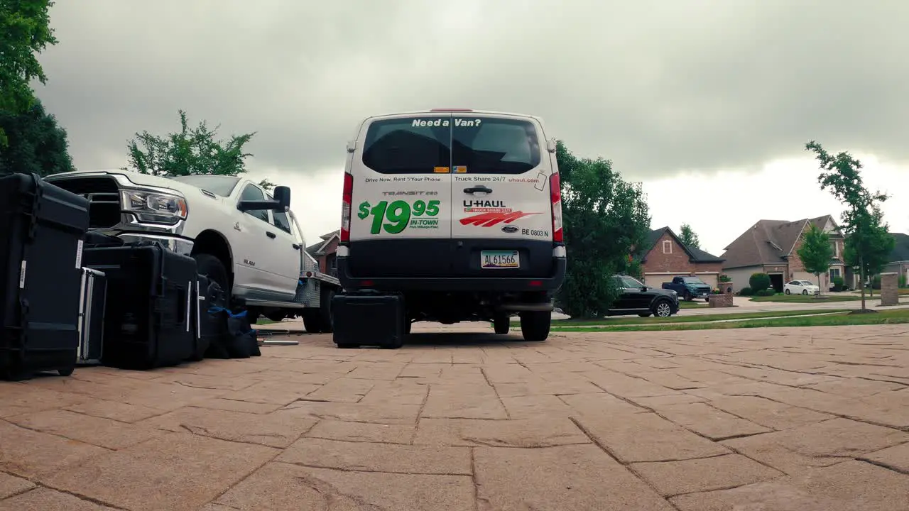 timelapse of a filming crew about to load gear into a uhaul van on a clody day low angle