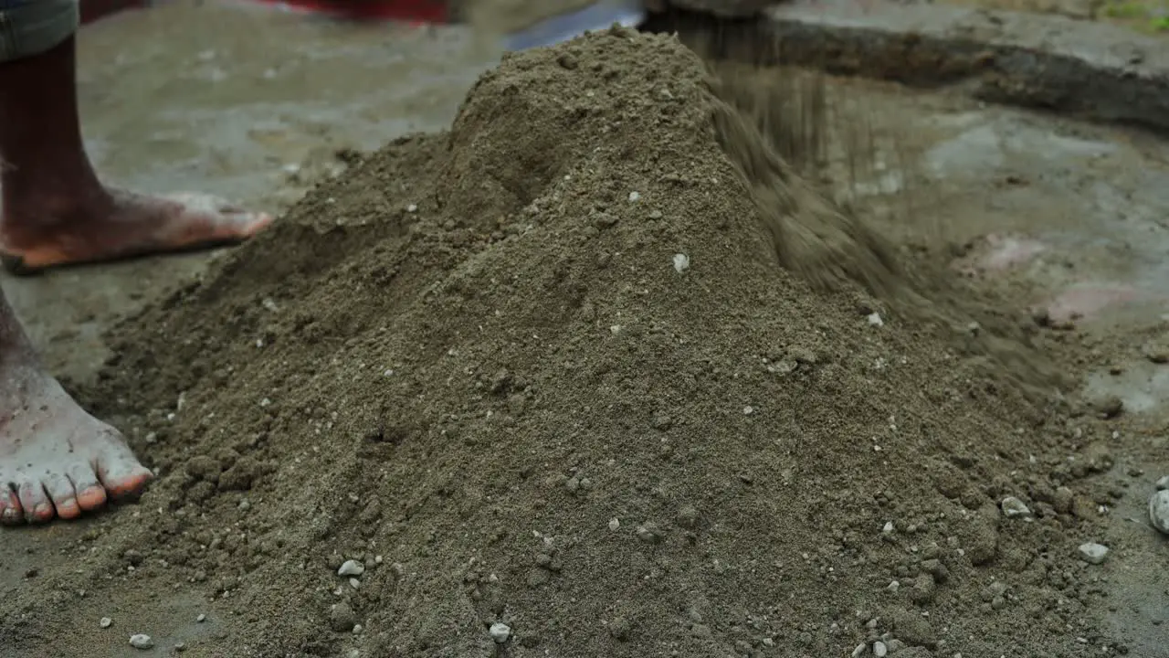 indian construction site barefoot labor mixing cement sand preparing for construction site work