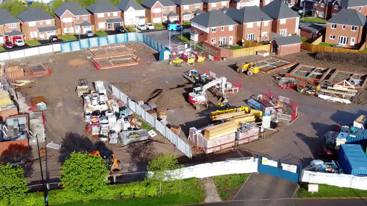 Construction site aerial view above new urban real estate housing development regeneration zoom in birdseye