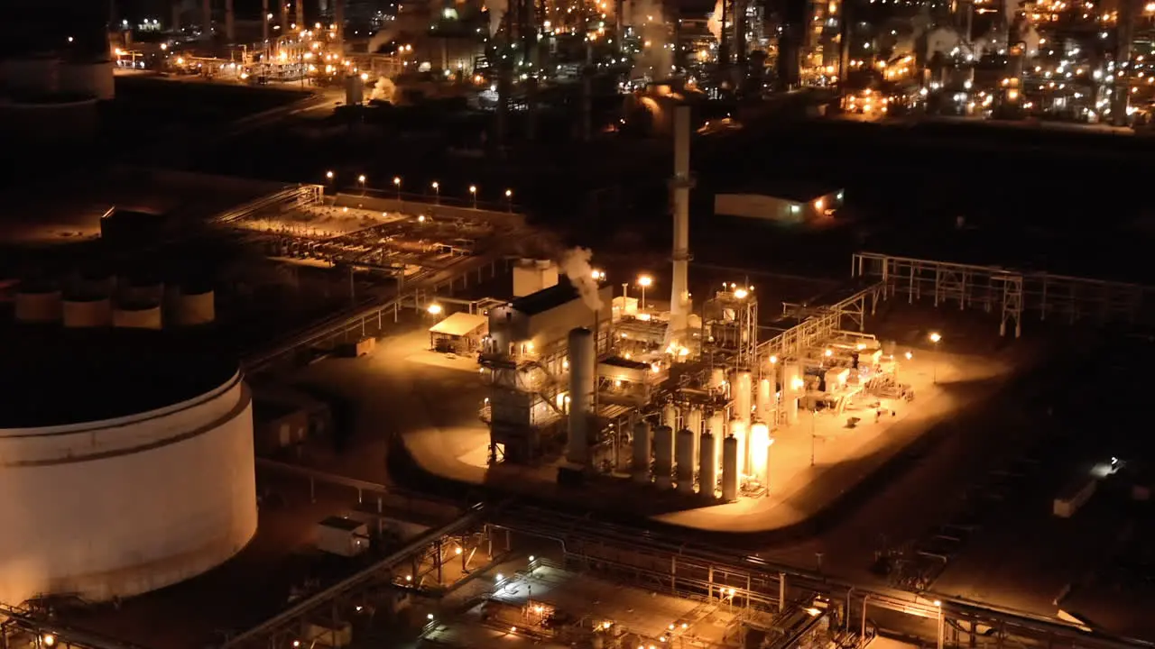 Aerial view of oil refinery process plant at night establishing view