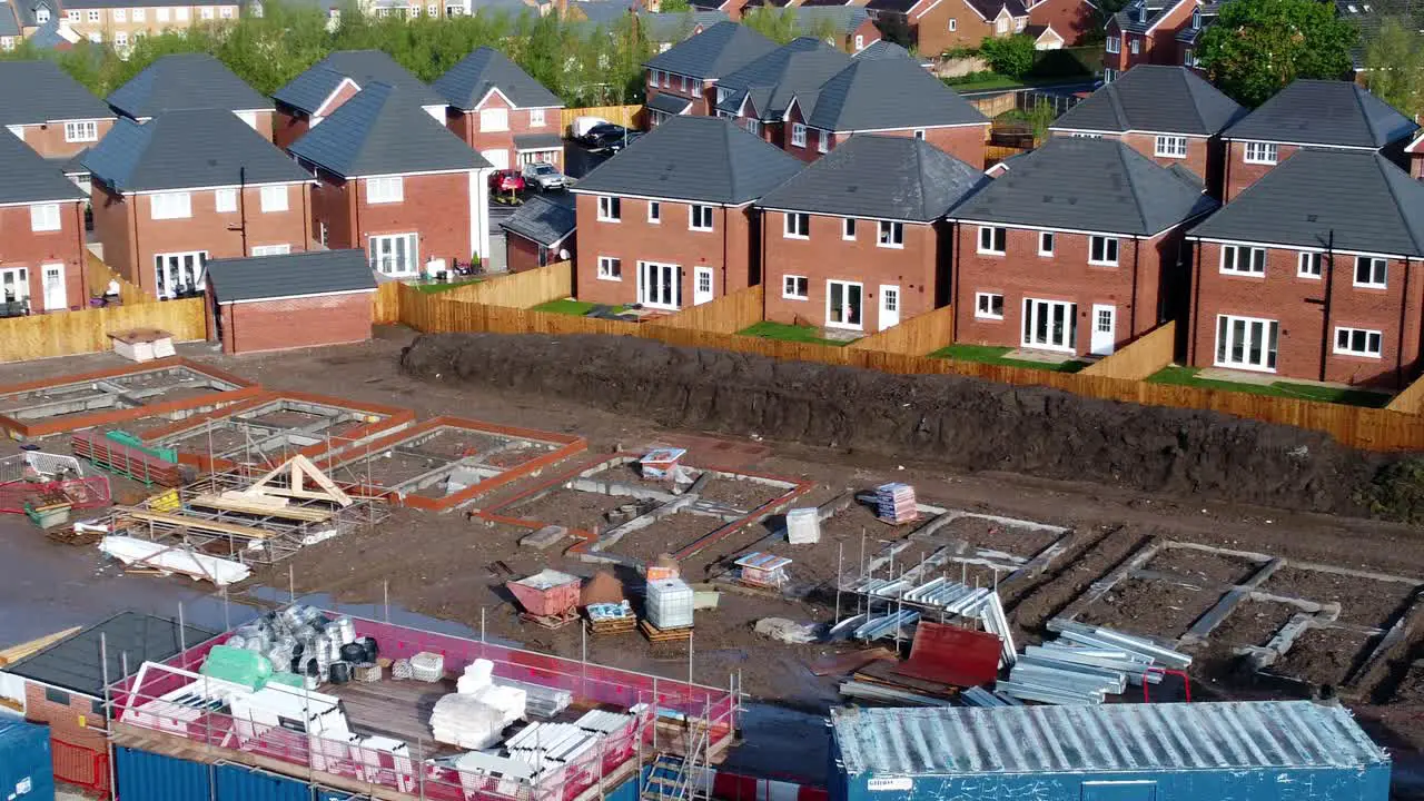 Construction site aerial view above new urban real estate housing development regeneration close low orbit right shot