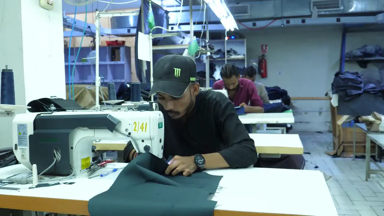  Pakistani Male Garment Worker Using Sewing Machine Inside Factory