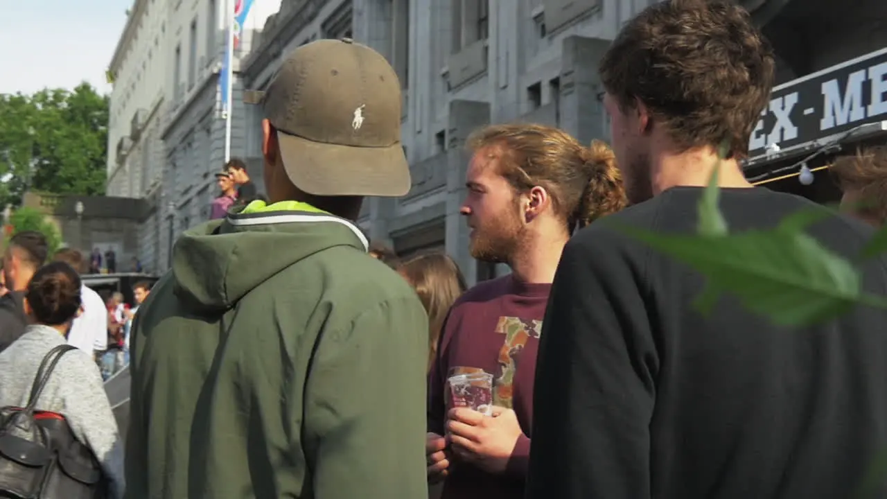 People having drinks and a good time next to a food stall and a wooden skate ramp