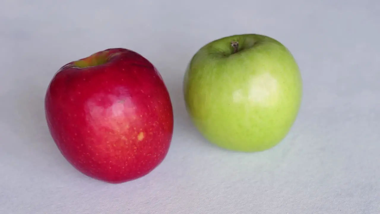 Hand Put Red And Green Apples On Table