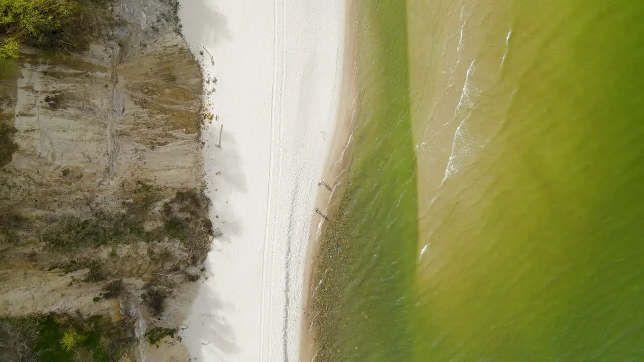 People walking along the Chlapowo beach near the baltic sea at the foot of a cliff Poland Aerial top-down view