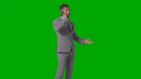 Three Quarter Length Studio Shot Of Smiling Businessman In Suit Talking On Mobile Phone Against Green Screen 2