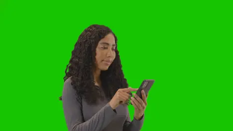 Profile Shot Of Woman Scrolling And Using Mobile Phone Against Green Screen