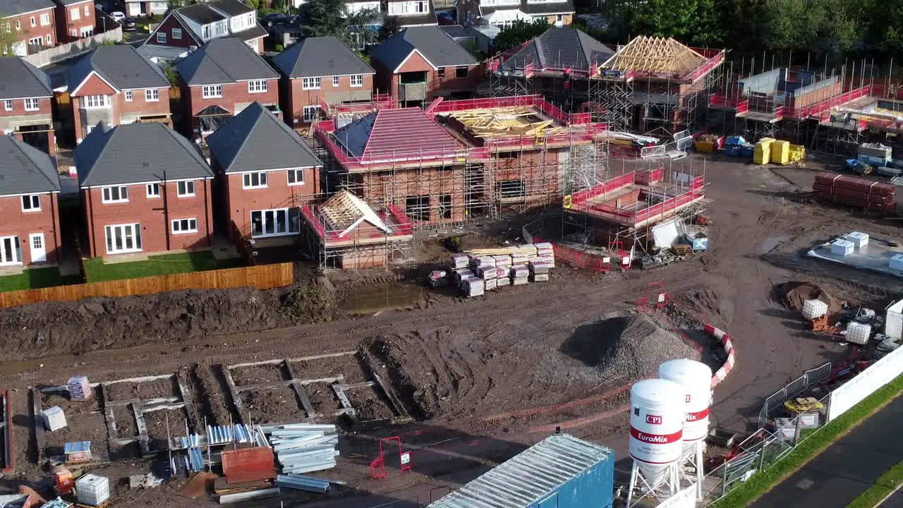 Construction site aerial view above new urban real estate housing development regeneration tilt up birdseye reveal