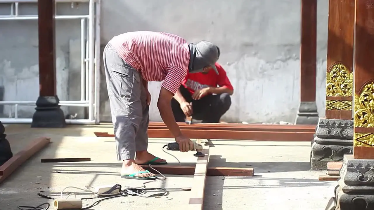 A carpenter is grinding wood for a building