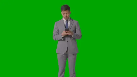 Studio Shot Of Frustrated Businessman In Suit Against Green Screen Looking At Mobile Phone 1