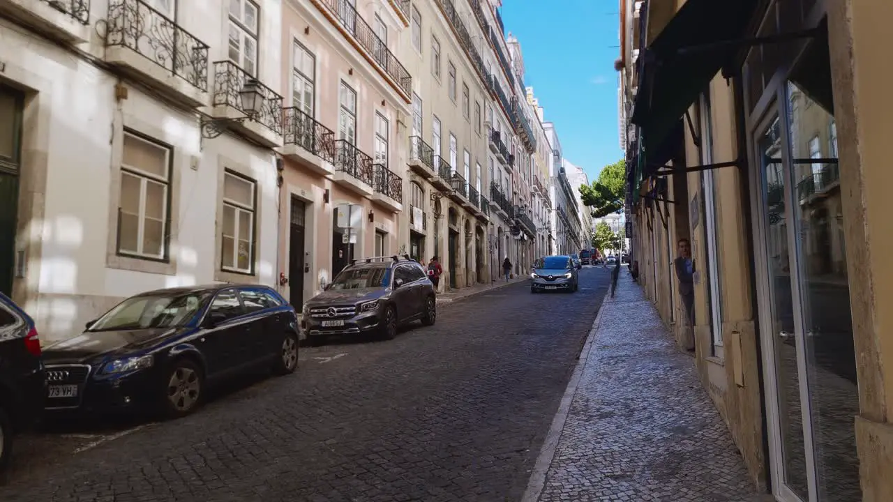 Local people going about their business in cars and on foot Lisbon Portugal