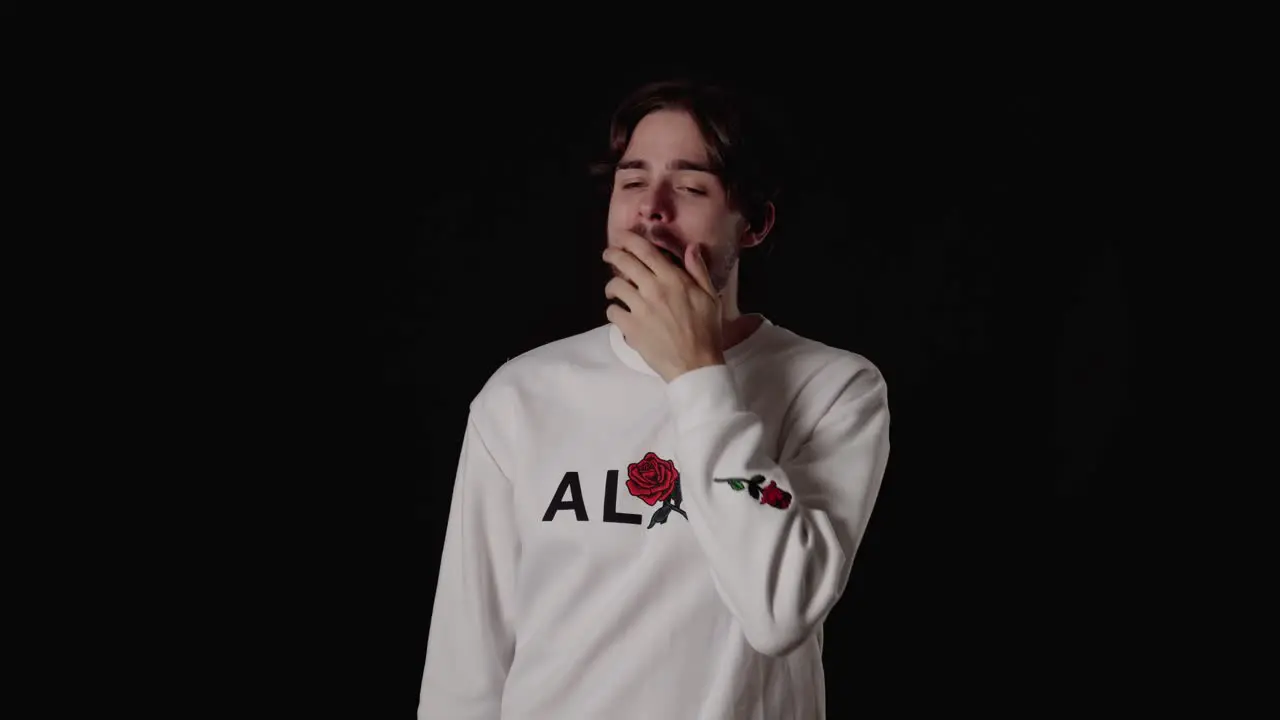 Trendy Young Man yawning tired gesture wide black background