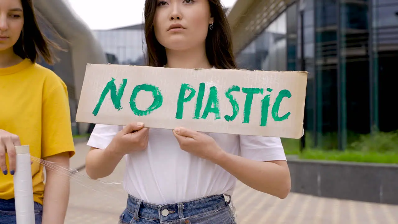 Woman Wrapping An Girl With Plastic Film