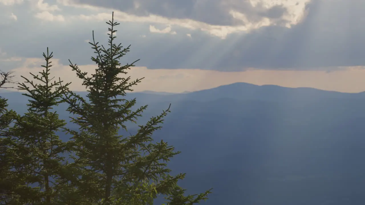 A mountain top landscape view at sunset with god rays of light coming down in Vermont