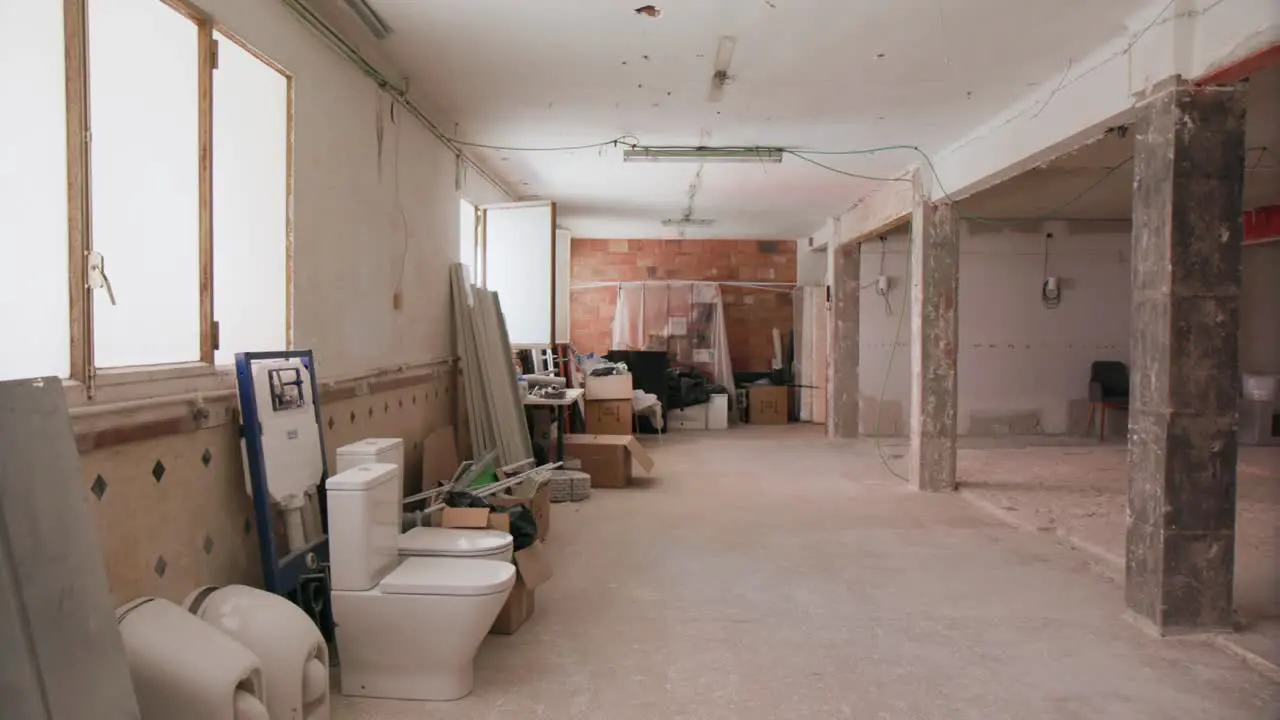 Panning around empty desolate building site room in a commercial building with exposed walls and cables