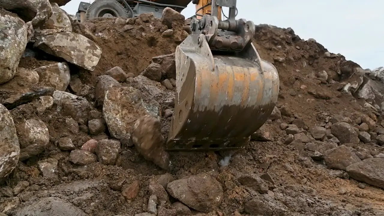 Close up of an excavator bucket working heavy equipment excavating soil and rocks no people