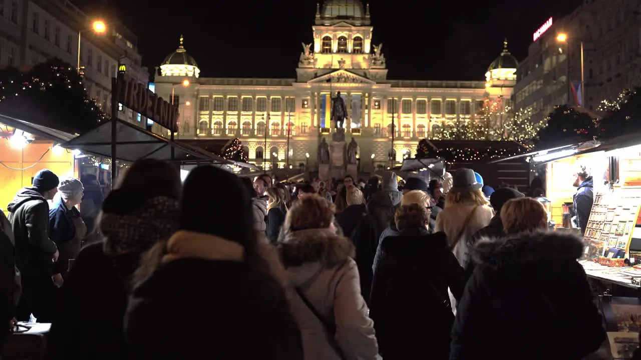 People walking through Christmas market below Prague National Museum