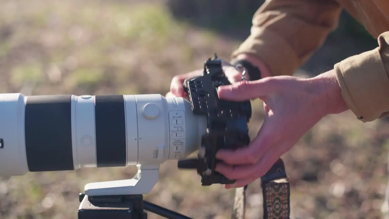 Man mounting a sony camera to a telephoto lens outside in the sun