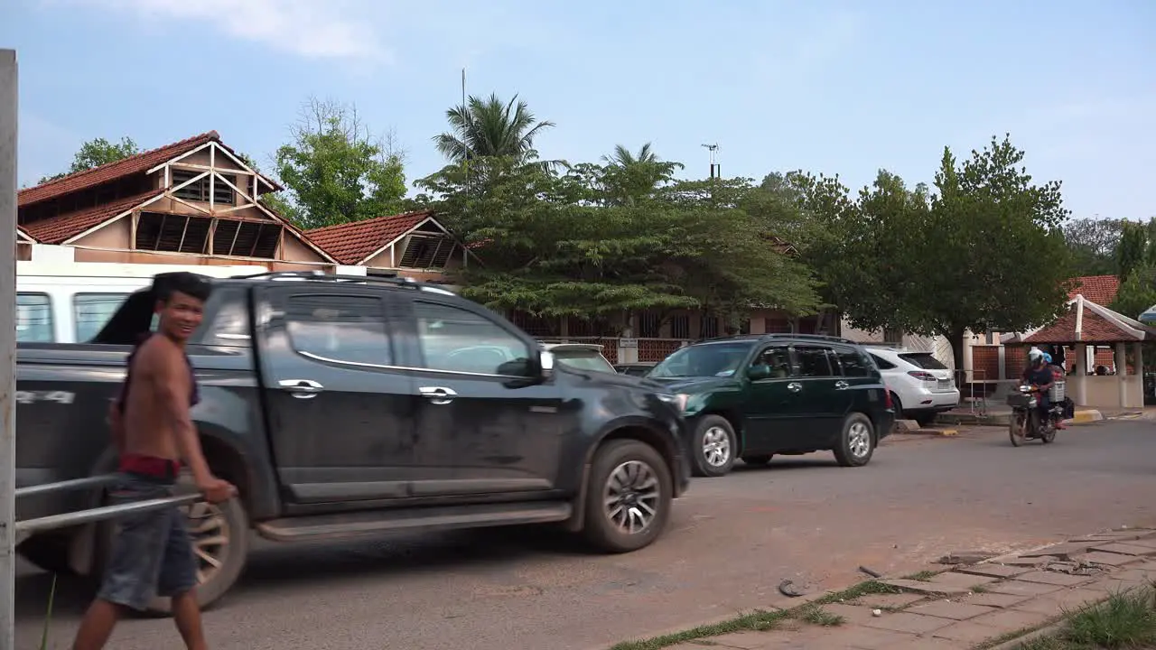 Two Khmer Guy Pushing a Wheelbarrow in a Traffic Jam