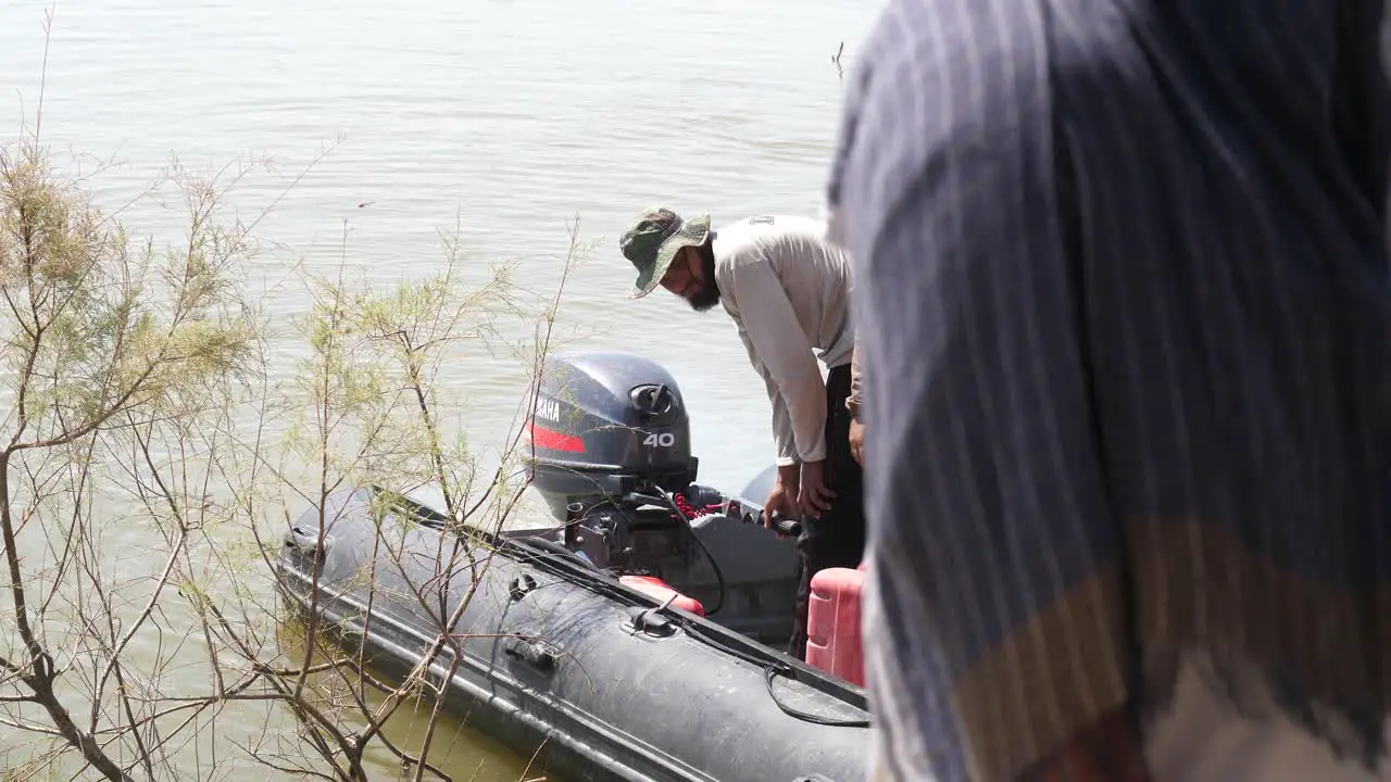 Pakistani Male Checking Inflatable Boat Motor Engine In Sindh Pakistan