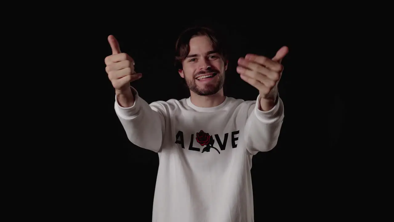 Trendy Young Man welcoming camera waving gesture wide black background