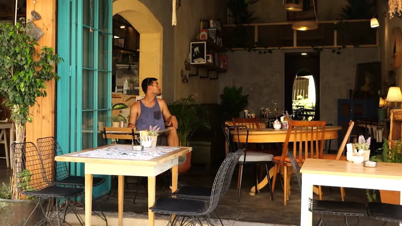 Male Tourist Sitting Alone In Cafe Looking Around In Nicosia Cyprus