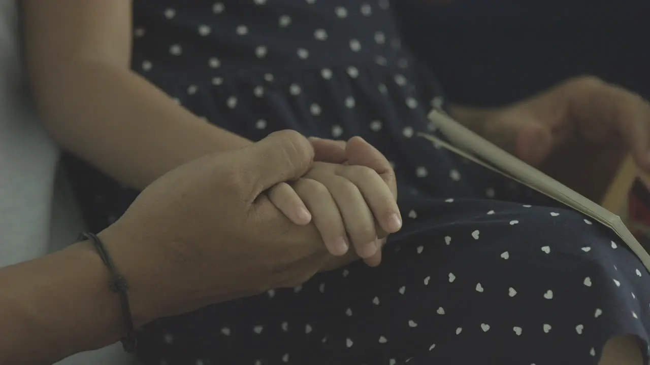 Father Holding Hands Of Daughter In His Lap