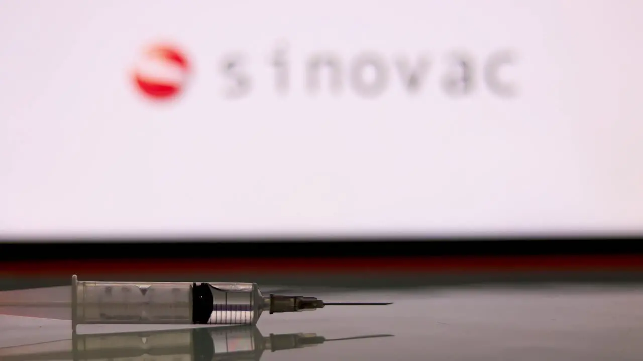 Syringe Injection placed in front of the Sinovac logo