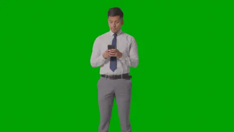 Studio Shot Of Businessman In Shirt And Tie Using Mobile Phone Against Green Screen 1