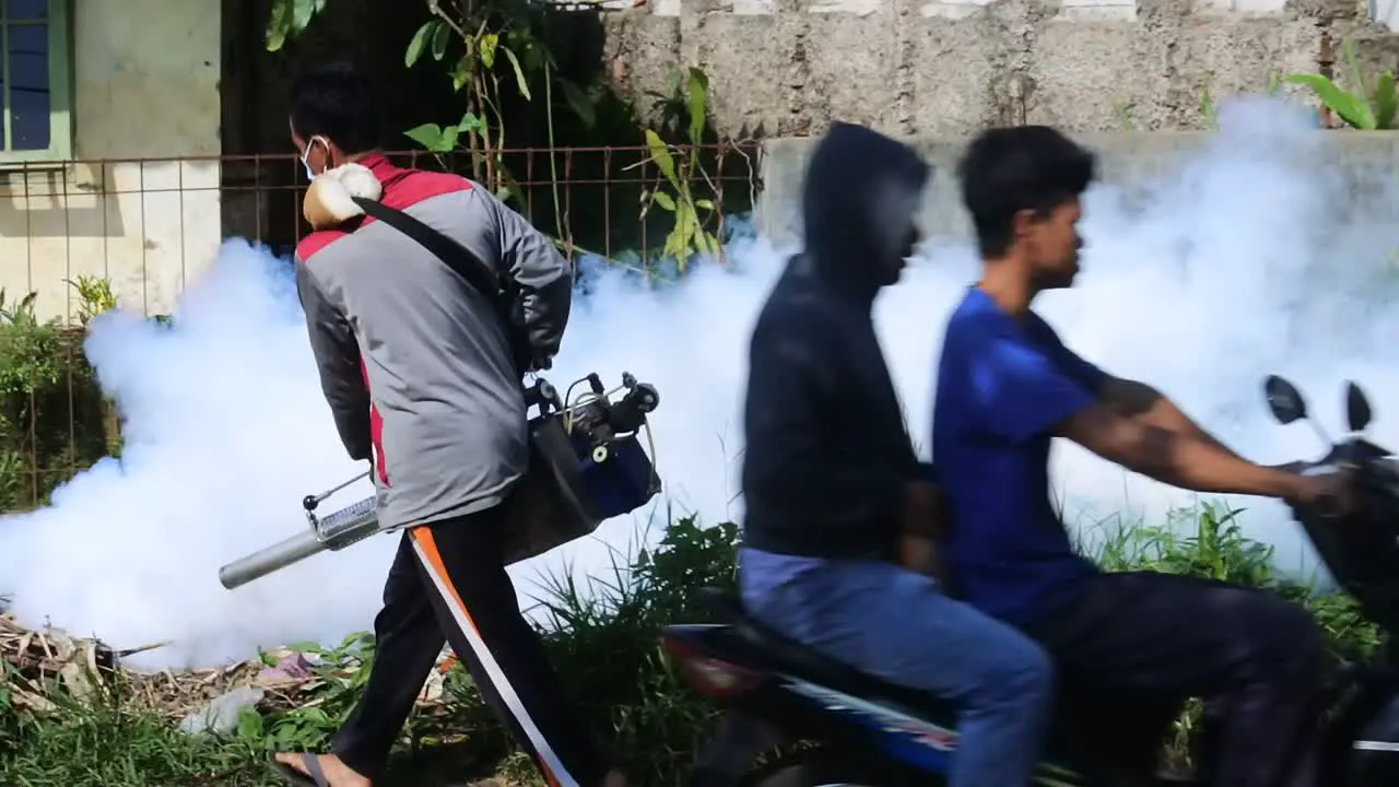 Professional person with equipment using a fogging machine with insecticide to Eliminate mosquitos as aedes aegypti in an outdoors environment in Sukabumi West Java Indonesia on May 8 2022