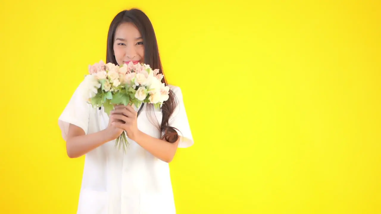 Asian female healthcare doctor offering bouquet flowers