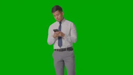 Studio Shot Of Businessman In Shirt And Tie Using Mobile Phone Against Green Screen 2