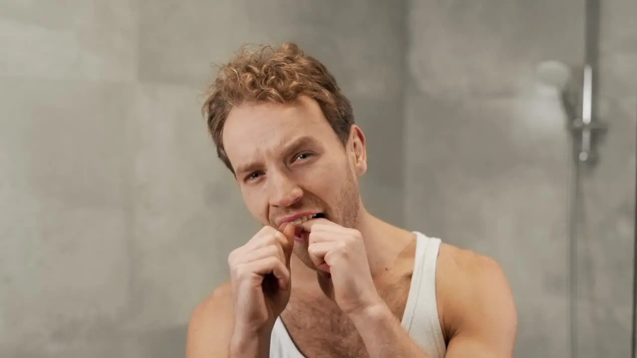 Portrait of a handsome man using dental floss