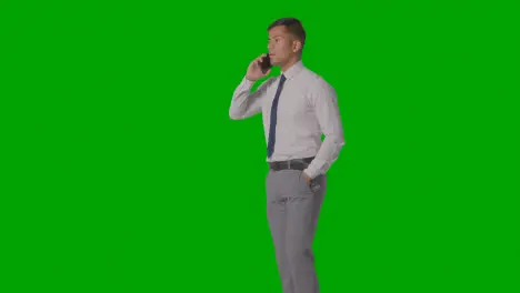 Studio Shot Of Businessman In Shirt And Tie Talking On Mobile Phone Against Green Screen 