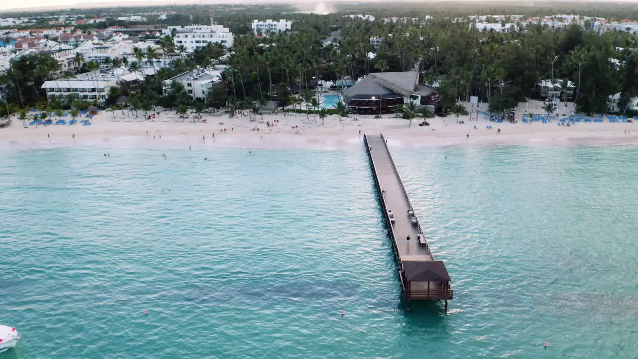 Wooden pier on beach in front of tropical resort area