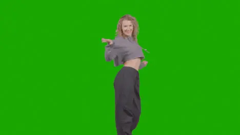 Studio Shot Of Young Woman Having Fun Dancing Against Green Screen 33