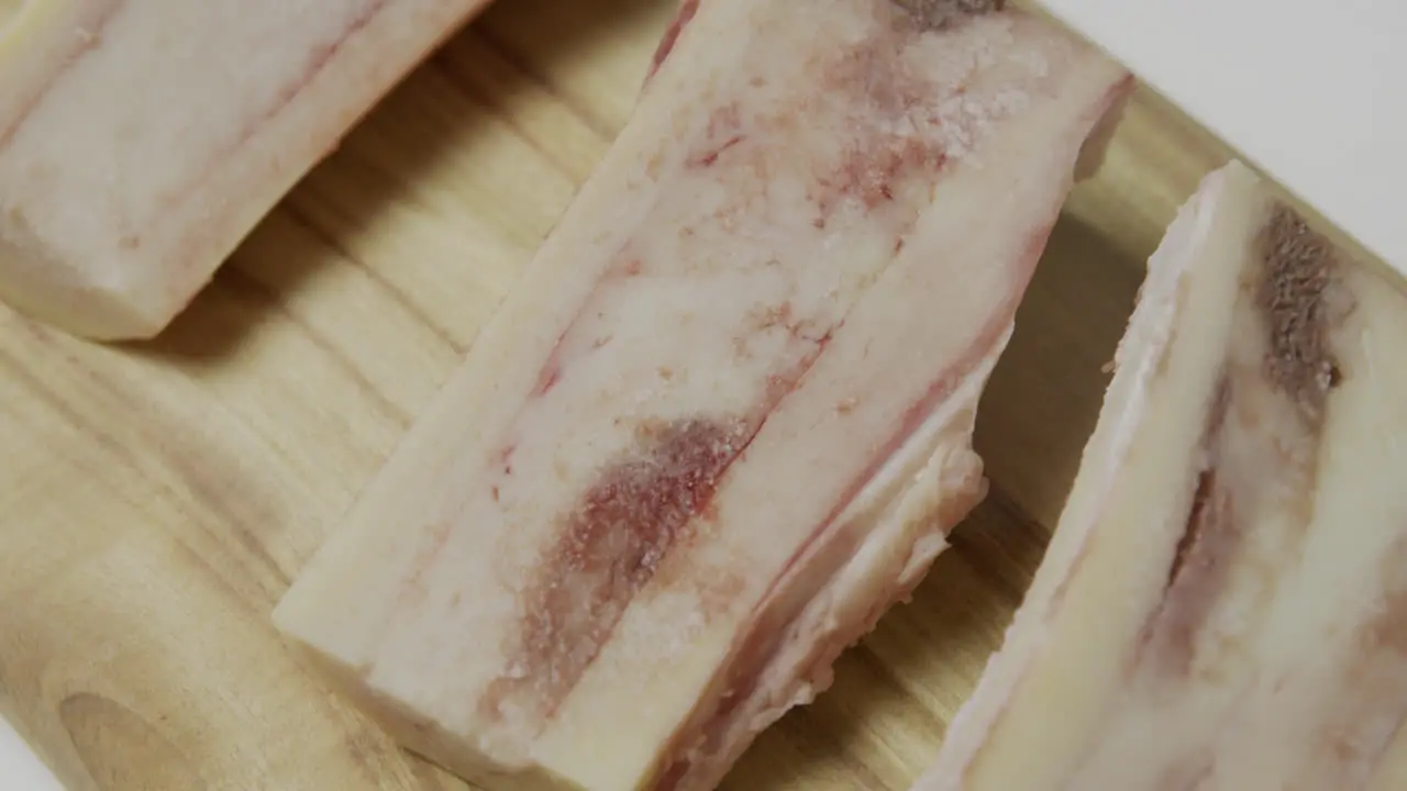 Bone marrow with blood spots placed on wooden cut board