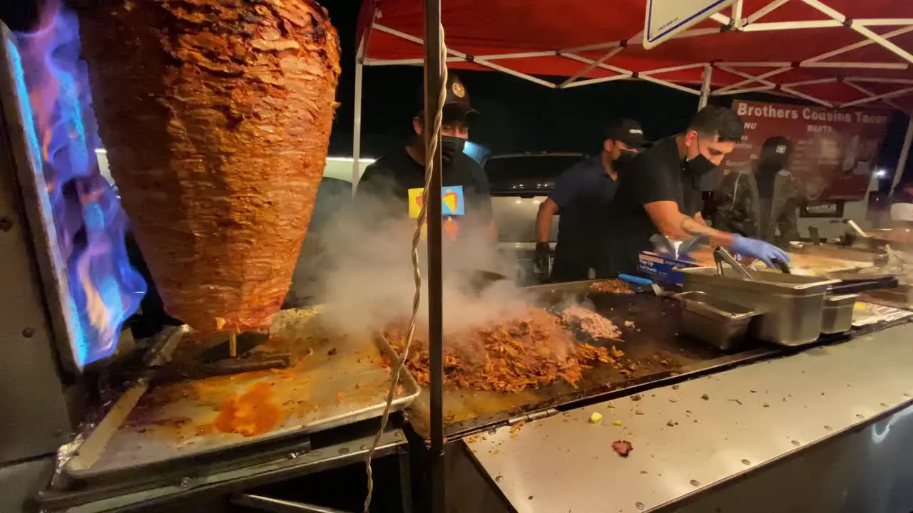 Taqueros preparando tacos al pastor con el trompo al lado carne Comida mexicana