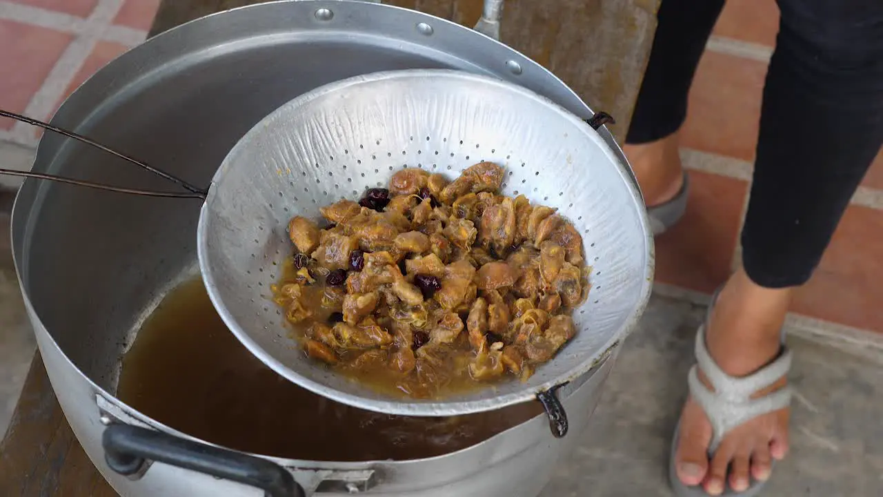 Tamarind pulp being strained in colander to prepare tamarind sauce