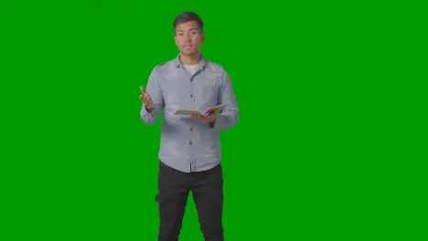 Three Quarter Length Shot Of Male Teacher Talking To School University Or College Class In Lesson Against Green Screen 