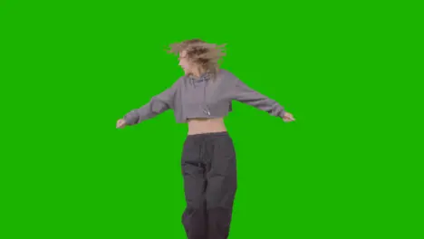 Full Length Studio Shot Of Young Woman Having Fun Dancing Against Green Screen 2